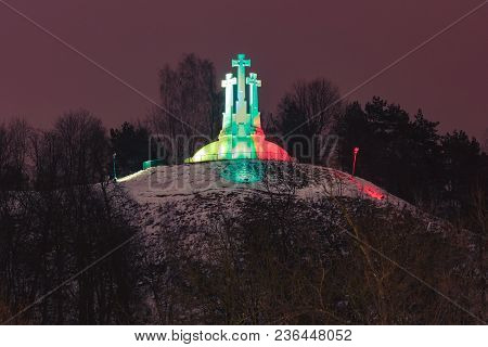 Three Crosses On The Bleak Hill Illuminated By The Colors Of The National Lithuanian Flag At Night O