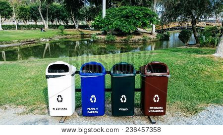 Different Colored Bins For Collection Of Recycle Materials Ubicated In A Park