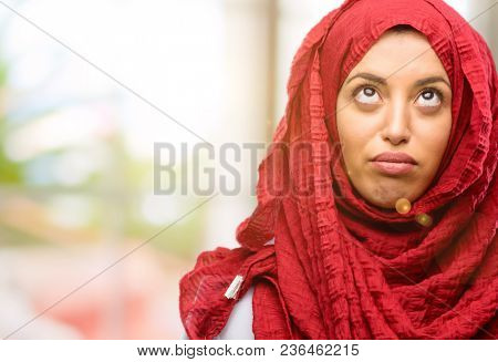 Young arab woman wearing hijab making funny face fooling