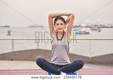 Sports Concept. Beautiful Girl Is Exercising On The Beach With Warm Up. Beautiful Girl Is Happy To E