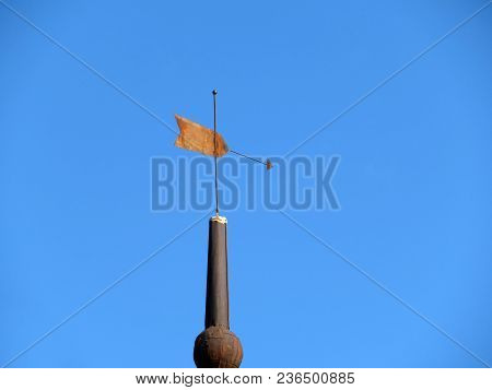 Old Rusty Weather Vane Against Clear Blue Sky. Vintage Windvane On Top Of The Tower