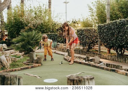 Group Of Two Funny Kids Playing Mini Golf, Children Enjoying Summer Vacation
