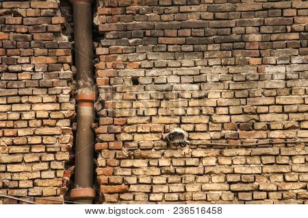 Old Grunge Weathered Brickwall With Stoneware Vitrified Clay Ceramic Drain Sewer Pipe Closeup