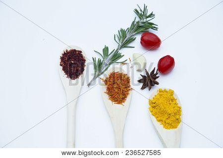 Cooking Hot Spicy Food Concept. Dry Spices And Herbs In Wooden Spoons, Fresh Herbs And Cherry Tomato