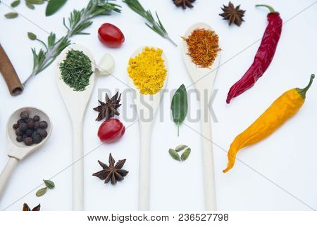 Cooking Hot Spicy Food Concept. Dry Spices And Herbs In Wooden Spoons, Fresh Herbs, Cherry Tomatoes 