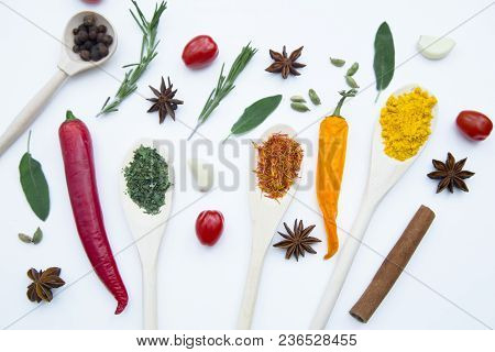 Cooking Hot Spicy Food Concept. Dry Spices And Herbs In Wooden Spoons, Fresh Herbs, Cherry Tomatoes 