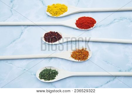 Cooking Hot Spicy Food Concept. Dry Spices And Herbs In Wooden Spoons White Marble Background, Top V