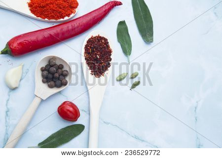 Cooking Hot Spicy Food Concept. Dry Spices And Herbs In Wooden Spoons, Fresh Herbs, Chili Peppers An