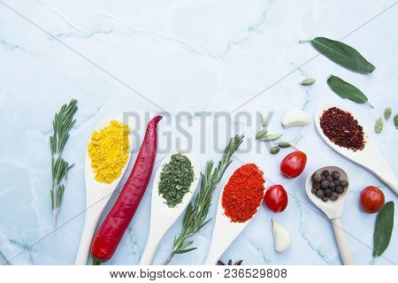 Cooking Hot Spicy Food Concept. Dry Spices And Herbs In Wooden Spoons, Fresh Herbs, Chili Peppers An