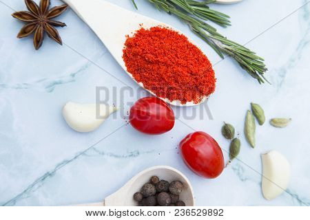 Cooking Hot Spicy Food Concept. Dry Spices And Herbs In Wooden Spoons, Fresh Herbs And Cherry Tomato