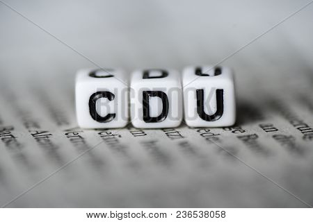 Word Cdu Formed By Wood Alphabet Blocks On Newspaper German Party Politics Closeup