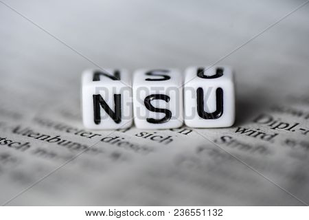 German Word Nsu Formed By Wood Alphabet Blocks On Newspaper Closeup