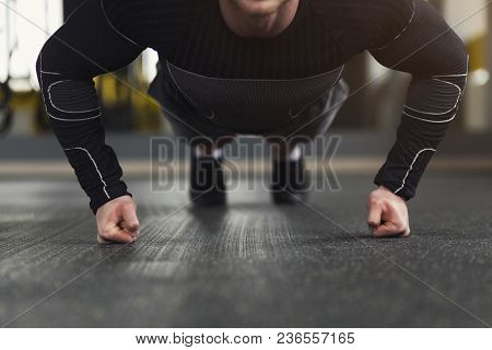 Young Man Workout In Fitness Club. Unrecognizable Guy Making Plank Or Push Ups Exercise On Fists, Tr