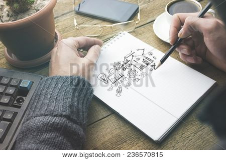Man Written Sketching Good Ideas With  Stationar  On Wooden Table