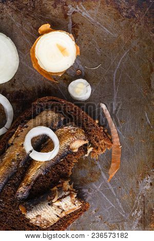 Canned Sprats In Tin Can With Rye Bread. On Rustic Background