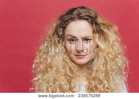 Attractive Female With Bushy Light Curly Hair, Raises Her Eyebrow, Feels Puzzlement, Can`t Undersatn