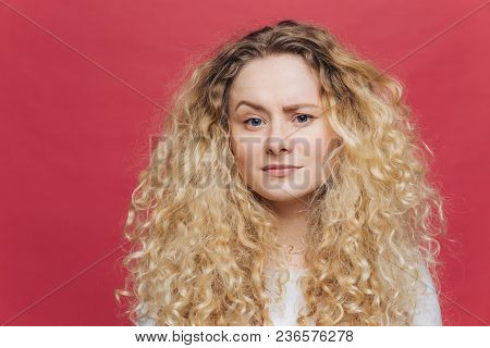 Young Attractive Woman Has Discontent Expression, Raises Eyebrow In Bewilderment, Being Dissatisfied