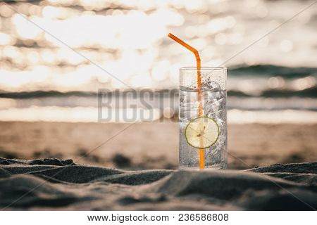 Glass Of Gin Tonic With Straw And Lime Slice On The Beach, At Sunset. Long Beach, Ko Lanta, Thailand