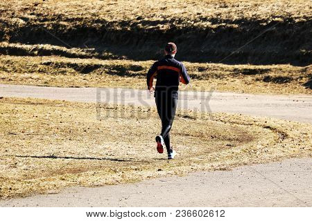 A Man Of Age Runs Around The Path, Taking Part In Sports.