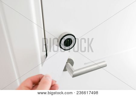 Hotel Door - Young Man Holding A Keycard In Front Of The Electronic Sensor Of A Room Door.