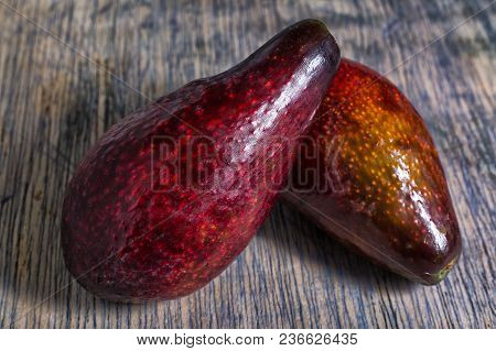 Whole Red Avocado Variety On Wood Surface In Ecuador