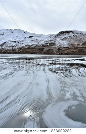 Snow pushed to one side of Unalaska Lake, Alaska.
