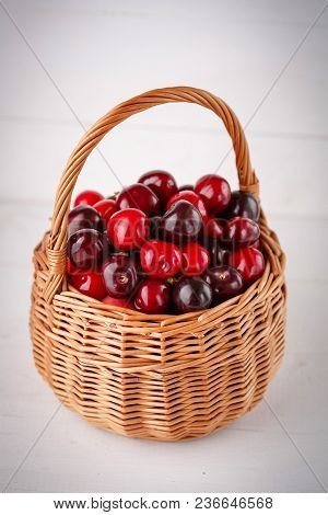 Ripe, Red And Weet Cherries In Basket On Wooden Background
