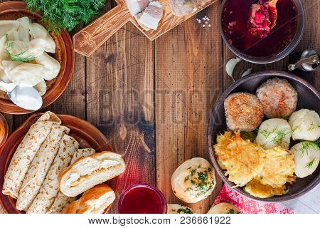 Traditional Dishes In Ukrainian Cuisine On A Wooden Table - Borsch, Vareniki, Pampushki With Garlic,