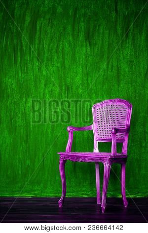 Old Purple Chair On A Green Wall Background