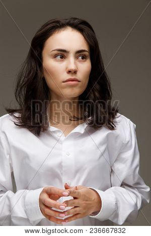 Beautiful Girl In A White Shirt Shows Emotions. On A Light Background.