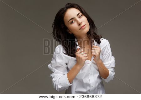 Beautiful Girl In A White Shirt Shows Emotions. On A Light Background.