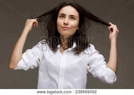 Beautiful Girl In A White Shirt Shows Emotions. On A Light Background.