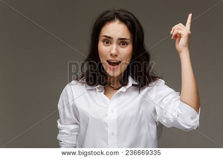 Beautiful Girl In A White Shirt Shows Emotions. On A Light Background.