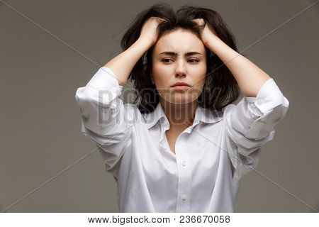 Beautiful Girl In A White Shirt Shows Emotions. On A Light Background.