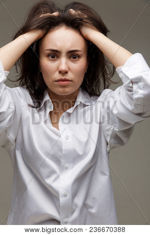 Beautiful Girl In A White Shirt Shows Emotions. On A Light Background.