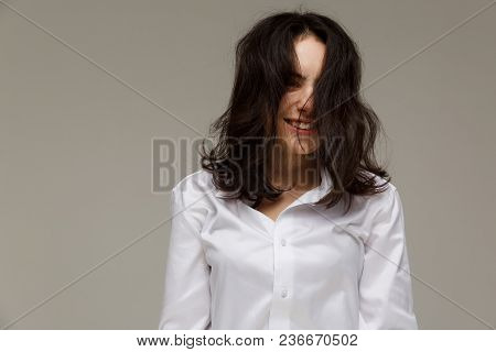 Beautiful Girl In A White Shirt Shows Emotions - Smile, Fun. On A Light Background.