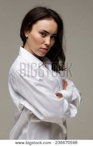Beautiful Girl In A White Shirt Shows Emotions. On A Light Background.