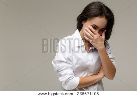 Beautiful Girl In A White Shirt Shows Emotions. On A Light Background.