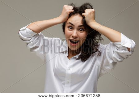 Beautiful Girl In A White Shirt Shows Emotions. On A Light Background.