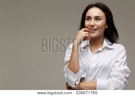Beautiful Girl In A White Shirt Shows Emotions. On A Light Background.
