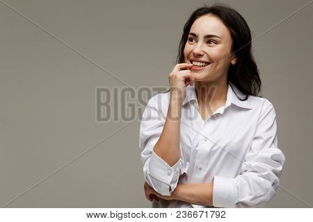 Beautiful Girl In A White Shirt Shows Emotions - Smile, Fun. On A Light Background.