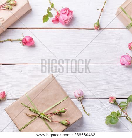 Flowers Composition. Gifts And Rose Flowers On White Wooden Table. Women Day. Flat Lay, Top View
