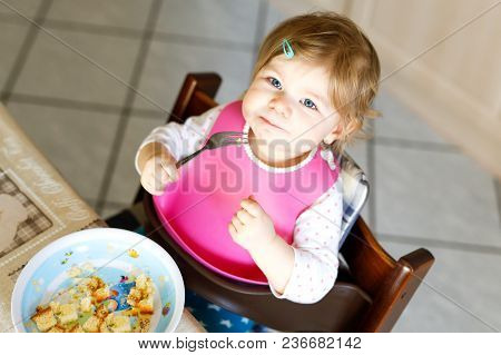 Adorable Baby Girl Eating From Spoon Mashed Vegetables And Puree. Food, Child, Feeding And Developme