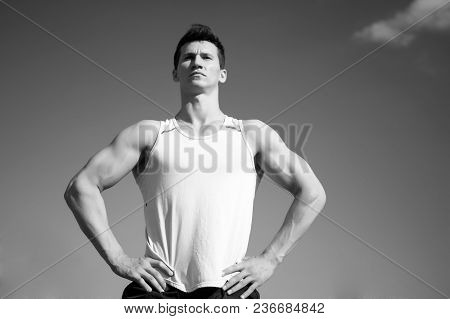Athlete In Green Tshirt On Sunny Day. Man Bodybuilder Posing On Blue Sky. Sport And Healthy Lifestyl