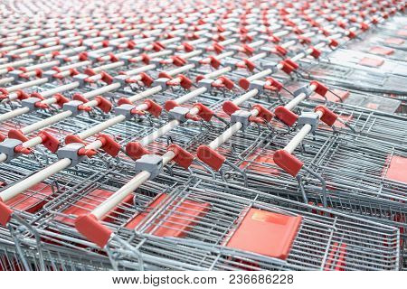 Red Shopping Cart. Trolley Pattern In Front Of A Supermarket, Ready For Customers To Use.