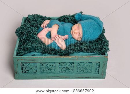 Newborn baby lying in wooden crate