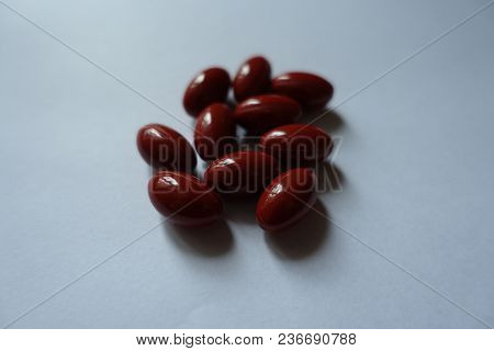Handful Of Red Capsules Of Lutein Dietary Supplement