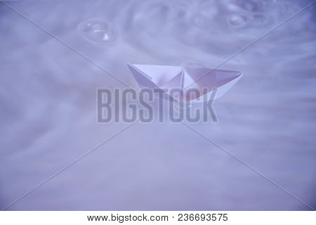 Small Folded Paper Ship On White Water As Symbold For Transportation And Tourism