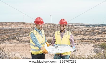 Workers Engineers Discussing Renewable Energy Project - Builders Planning How To Build A New Wind Fa
