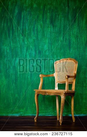 Old Chair On A Green Wall Background